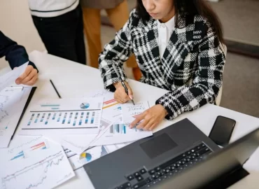 Professionals reviewing financial documents and charts during a cross-border tax planning discussion involving U.S. and Canadian reporting.